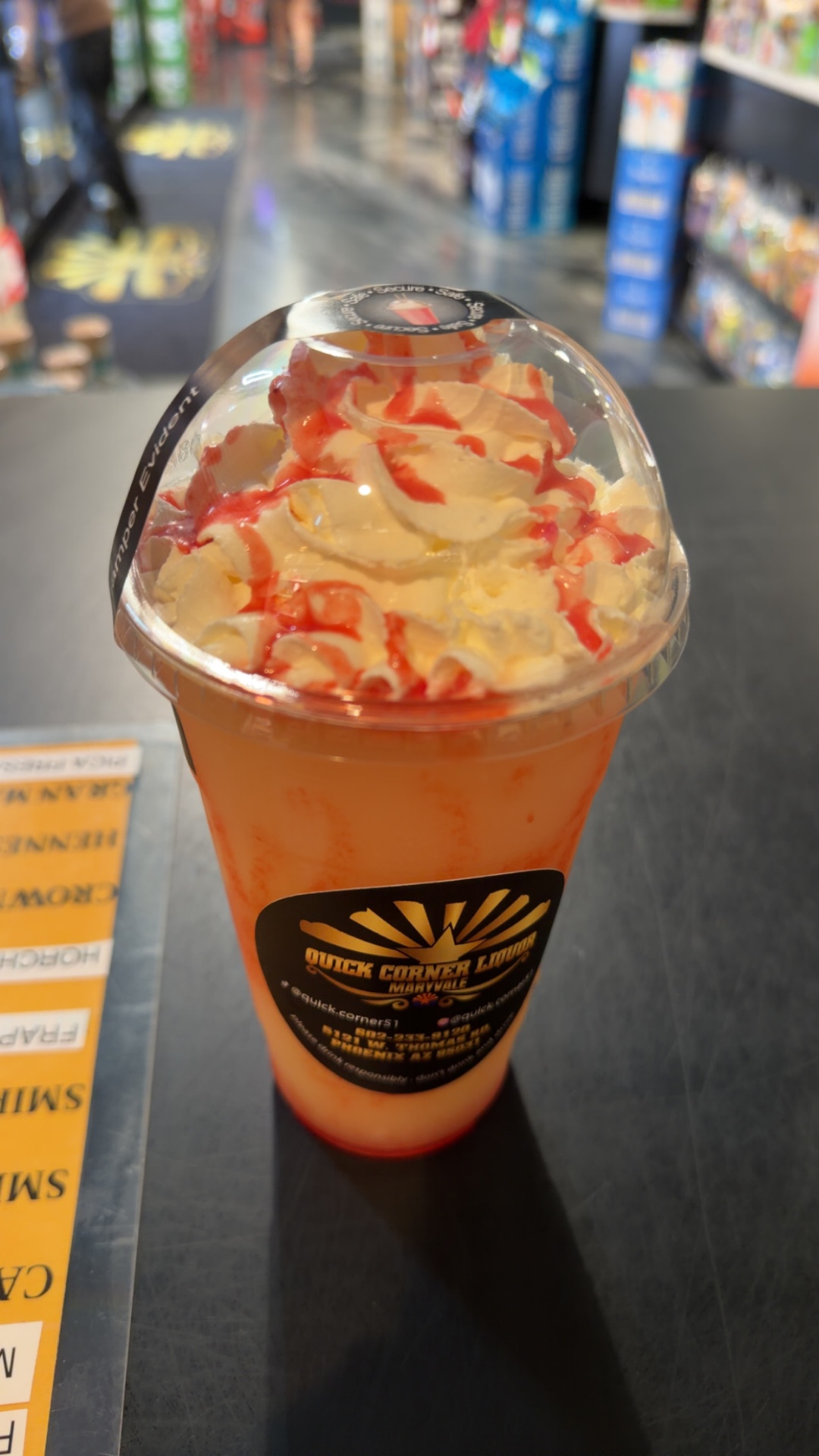 Domed-lid strawberry shortcake slushie topped with whipped cream and strawberry drizzle